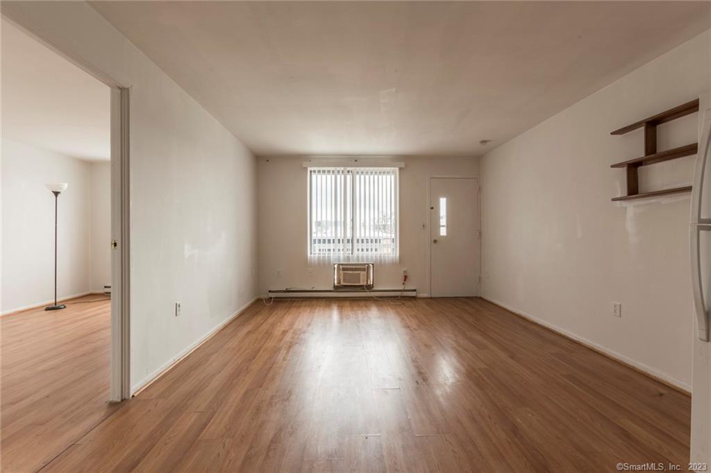 69 Cove Road, Unit C16 Stamford, CT 06902 - Photo 1 of 1 an empty room with wooden floor and windows