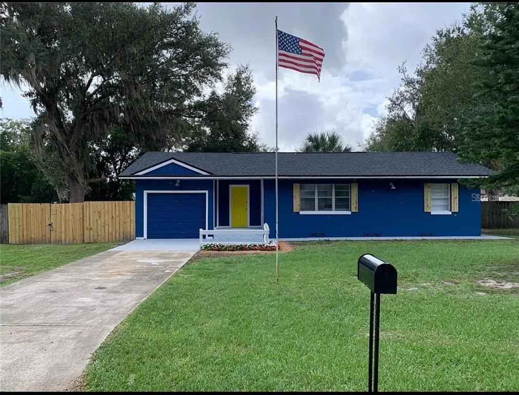 a view of a yard in front of a house with a large tree