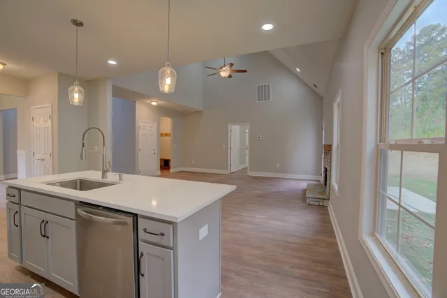a hall with kitchen island a sink granite countertops with a dining table chairs