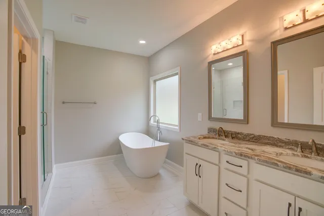 a spacious bathroom with a granite countertop sink and a mirror