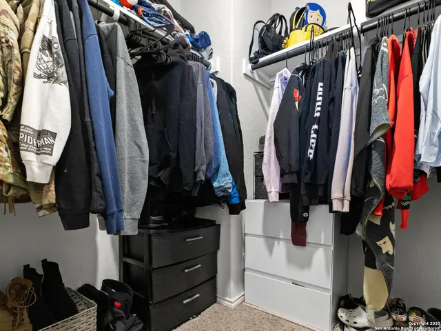 a view of walk in closet with clothes and shoes