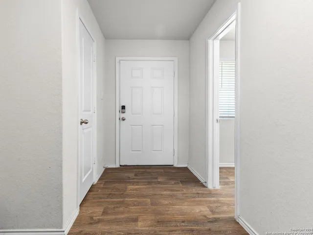 a view of a hallway with wooden floor