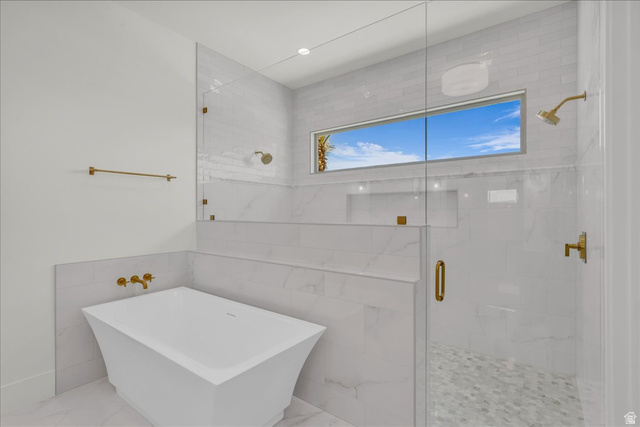 1620 Belayer Drive St. George, UT 84770 - Photo 25 of 51 Bathroom featuring a freestanding tub, glass-enclosed shower with gold-tone fixtures, and patterned shower floor tiling