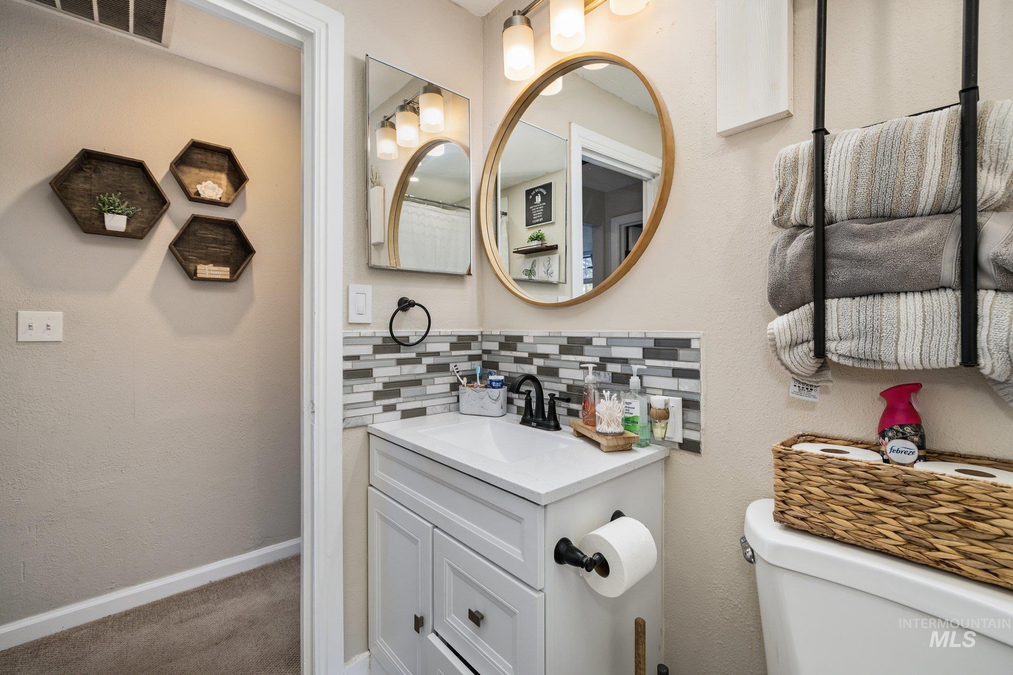1504 2nd Street North Nampa, ID 83687 - Photo 22 of 29 Bathroom featuring vanity, a textured wall, and tasteful backsplash