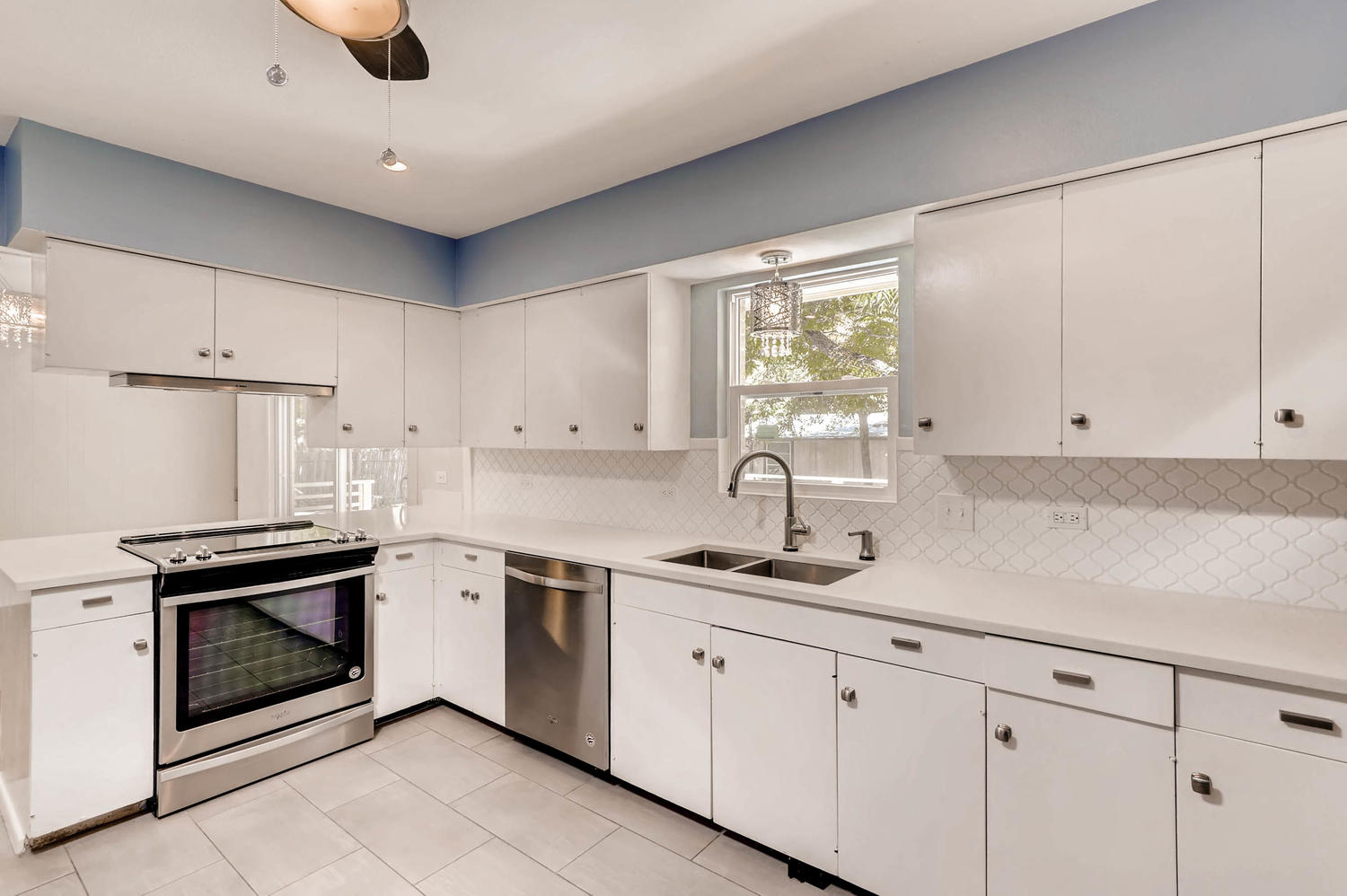 446 Pike Road San Antonio, TX 78209 - Photo 10 of 28 A well-lit kitchen with sleek white cabinetry, stainless steel appliances, and elegant tile flooring.