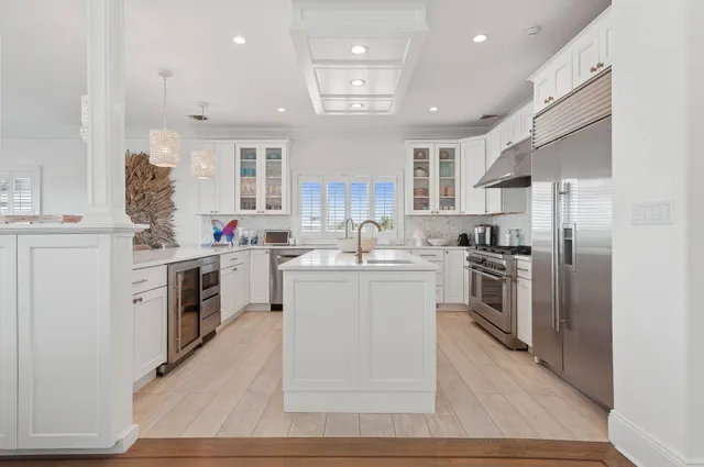 a kitchen with white cabinets and stainless steel appliances