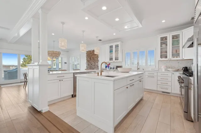a kitchen with white cabinets and sink