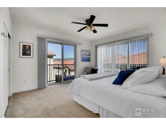 a bedroom with a bed a couch and a large window