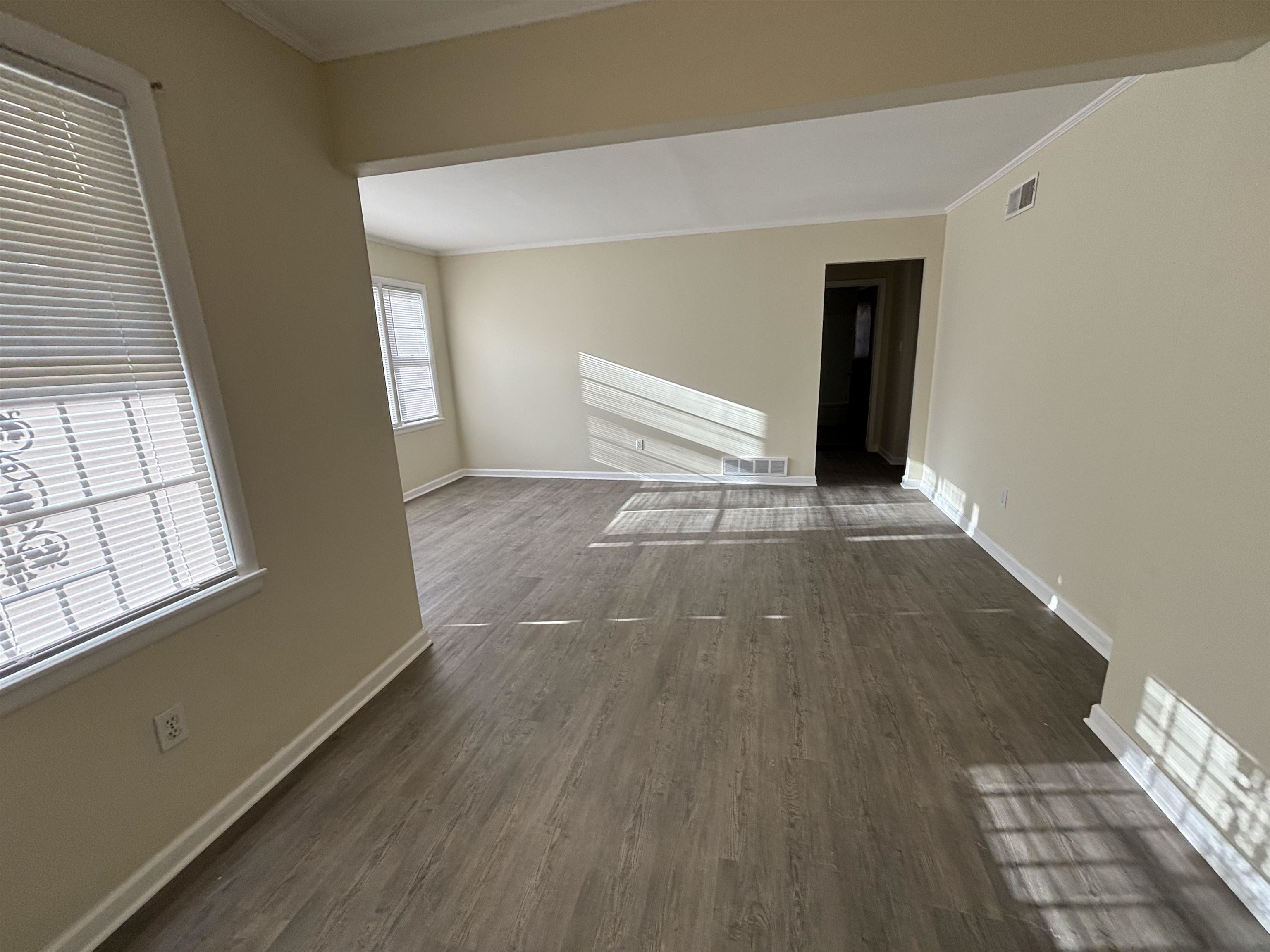 1548 Ivy Road Memphis, TN 38117 - Photo 4 of 14 a view of an empty room with wooden floor and a window