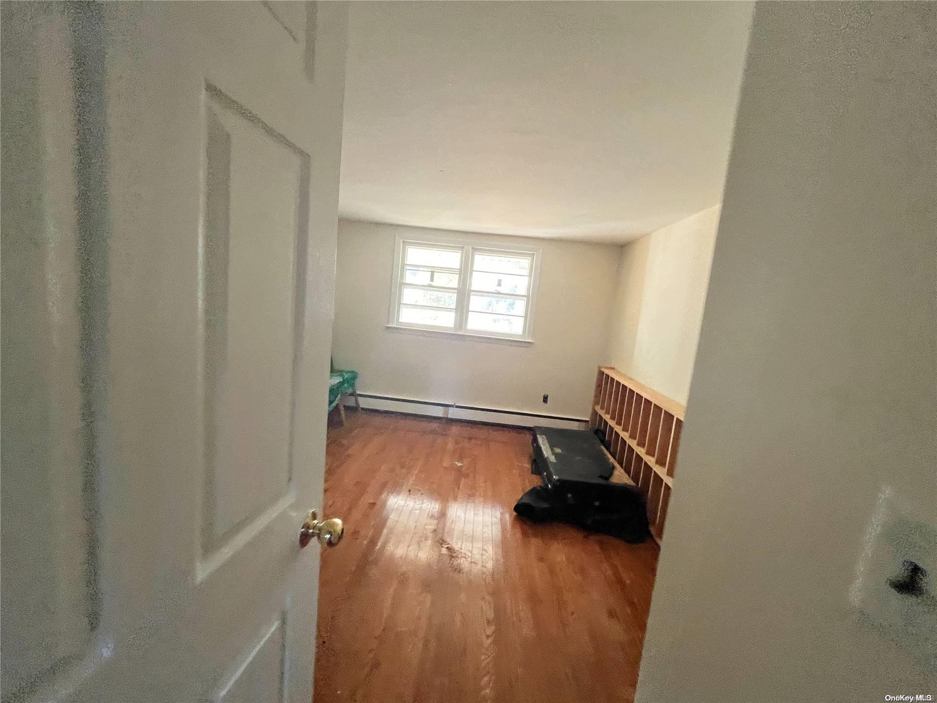 68 Tarpon Road Rocky Point, NY 11778 - Photo 21 of 23 an empty room with wooden floor and a window