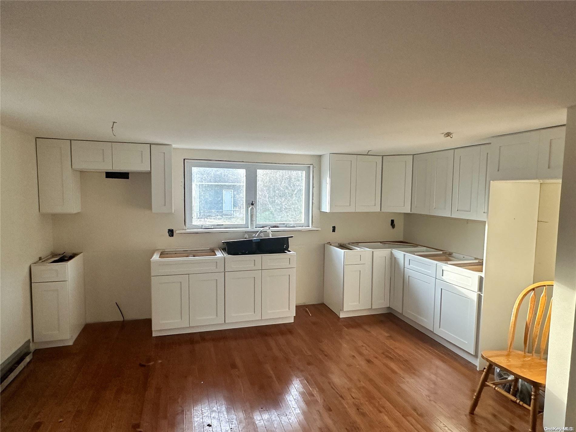 68 Tarpon Road Rocky Point, NY 11778 - Photo 7 of 23 a kitchen with white cabinets and white appliances