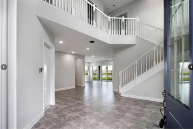 an empty room with wooden floor and window