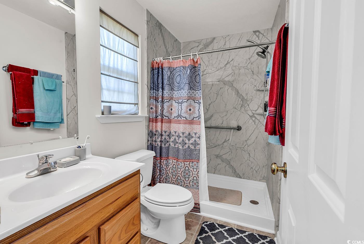 454 Sean River Road Conway, SC 29526 - Photo 19 of 38 Bathroom featuring a stall shower, vanity, toilet, and tile patterned flooring