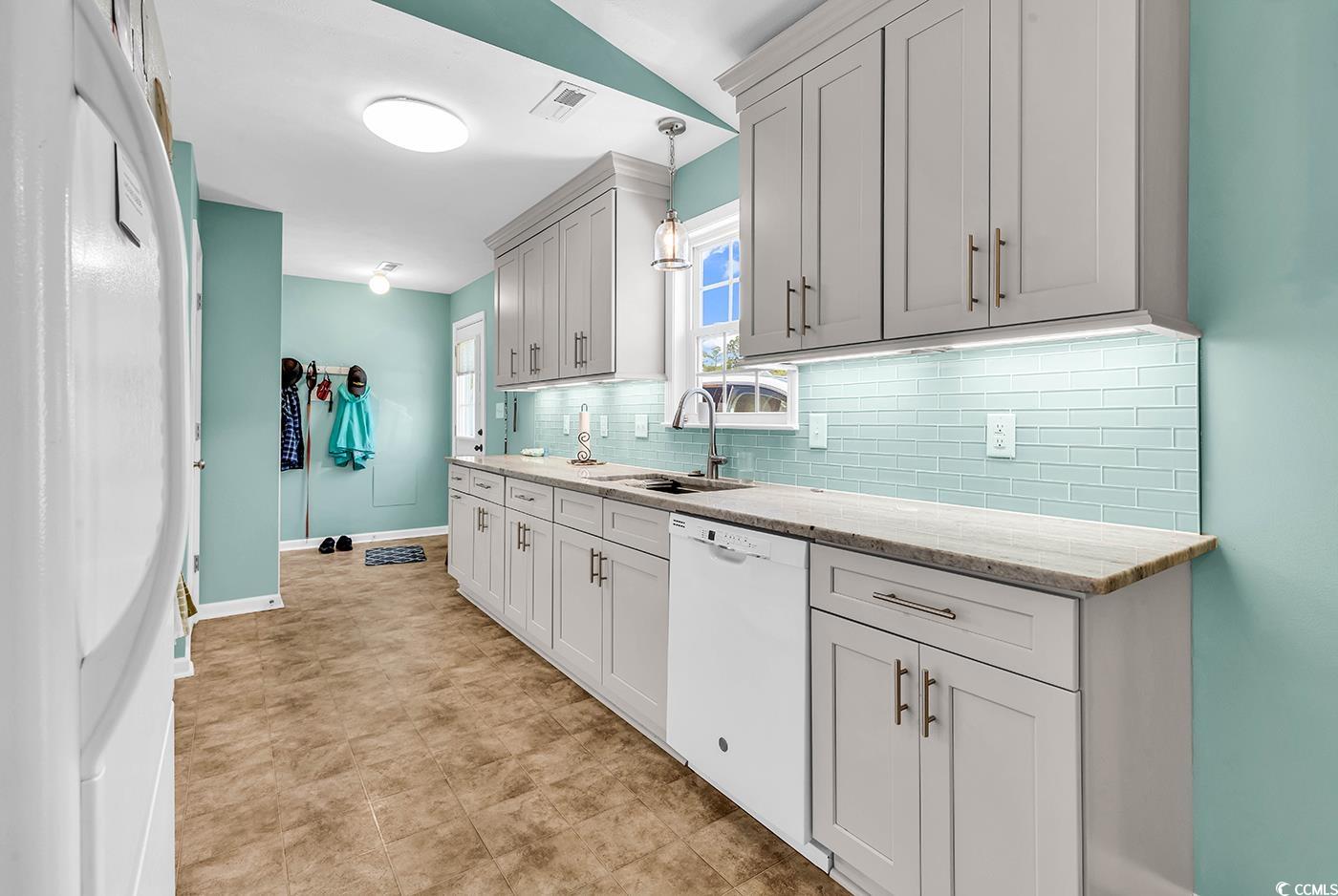 454 Sean River Road Conway, SC 29526 - Photo 2 of 38 Kitchen featuring dishwasher, a sink, backsplash, baseboards, and hanging light fixtures