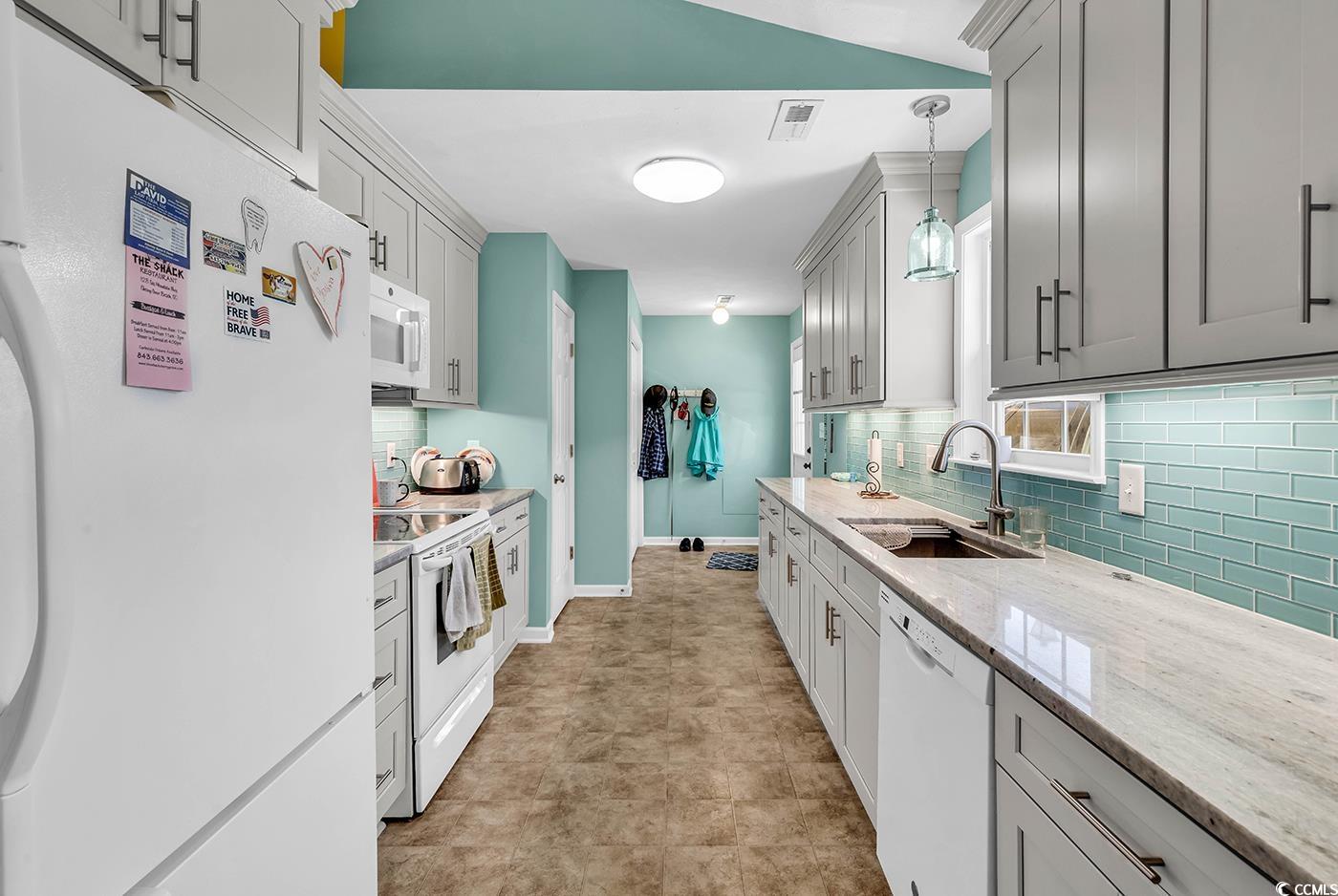 454 Sean River Road Conway, SC 29526 - Photo 3 of 38 Kitchen with white appliances, a sink, backsplash, light stone counters, and decorative light fixtures