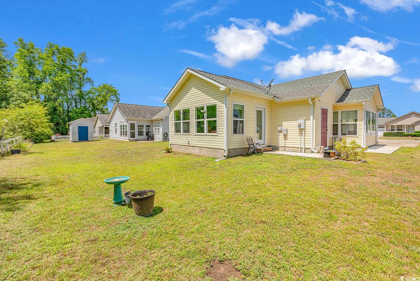 454 Sean River Road Conway, SC 29526 - Photo 36 of 38 Rear view of property featuring a patio, a lawn, an outbuilding, a storage shed, and roof with shingles
