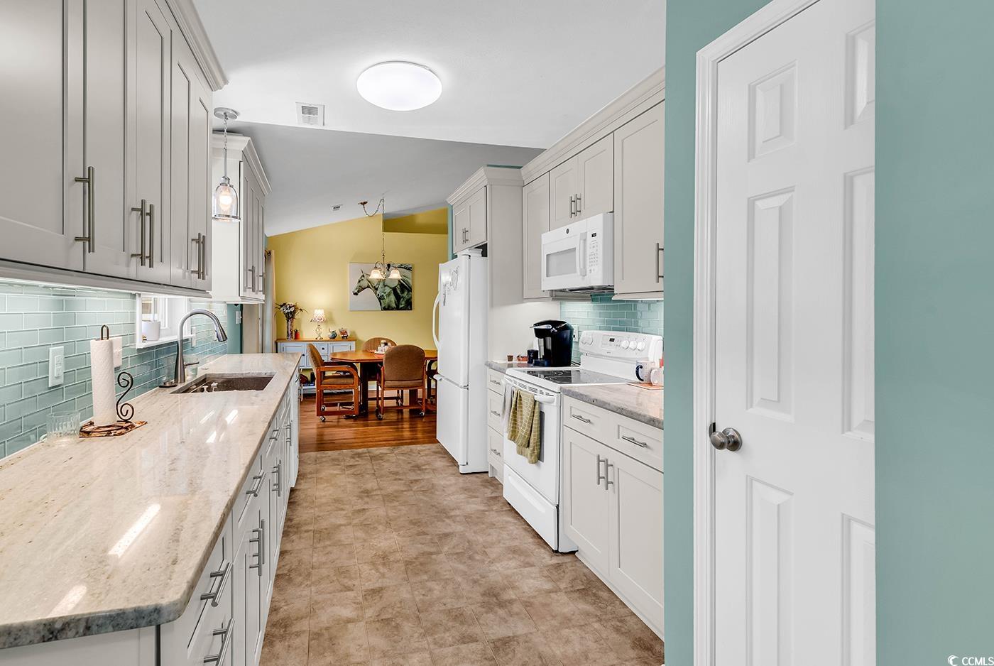 454 Sean River Road Conway, SC 29526 - Photo 5 of 38 Kitchen featuring white appliances, a sink, tasteful backsplash, lofted ceiling, and light stone countertops