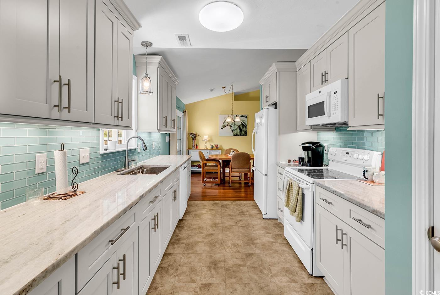 454 Sean River Road Conway, SC 29526 - Photo 6 of 38 Kitchen with white appliances, a sink, backsplash, hanging light fixtures, and light stone counters