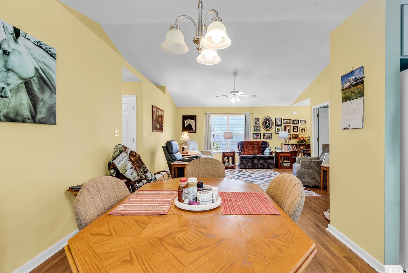 454 Sean River Road Conway, SC 29526 - Photo 9 of 38 Dining area featuring vaulted ceiling, a chandelier, wood finished floors, baseboards, and ceiling fan