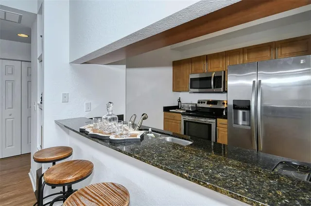 a kitchen with stainless steel appliances a stove microwave and sink