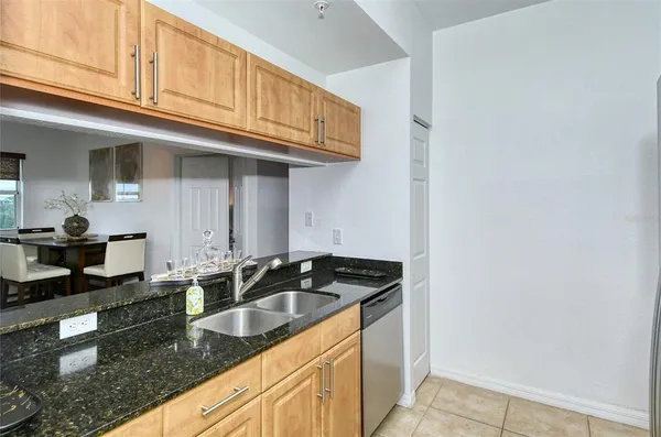 a kitchen with granite countertop a sink a stove and cabinets