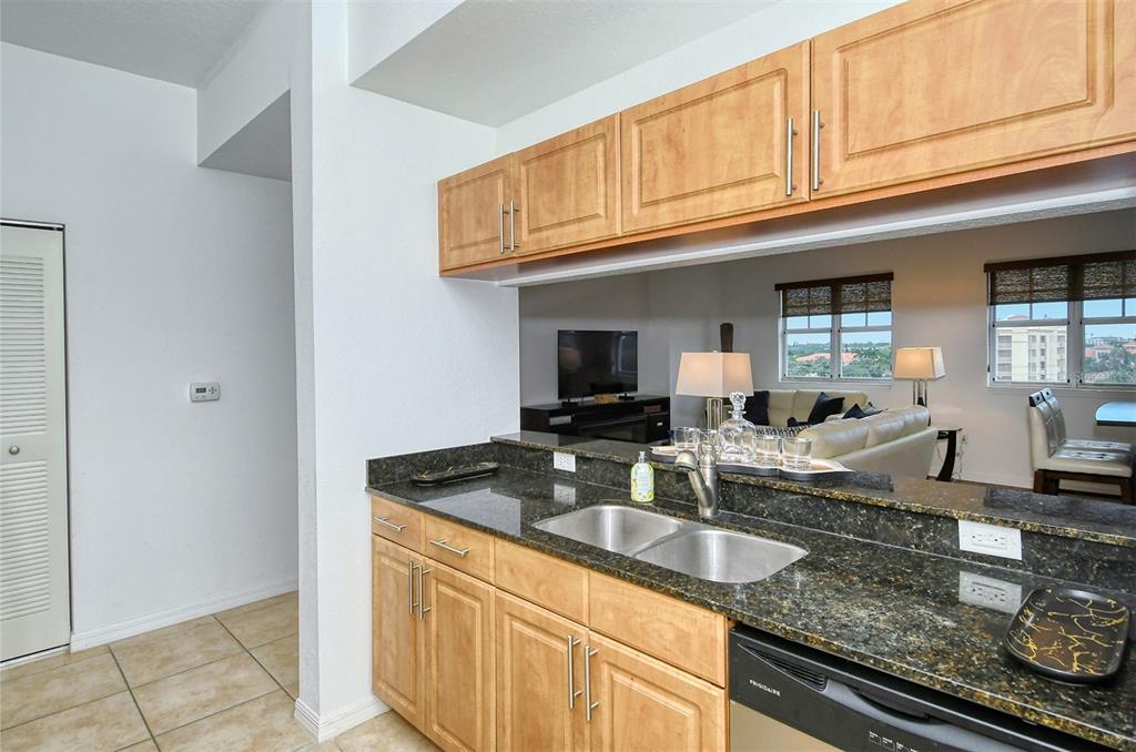 1064 North Tamiami Trail, Unit 1627 Sarasota, FL 34236 - Photo 15 of 97 a kitchen with granite countertop a sink a stove and cabinets