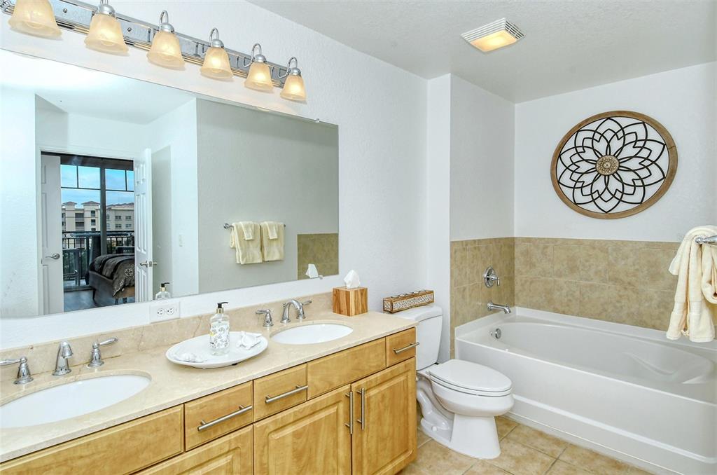 1064 North Tamiami Trail, Unit 1627 Sarasota, FL 34236 - Photo 23 of 97 a bathroom with a bath tub a sink and a large mirror