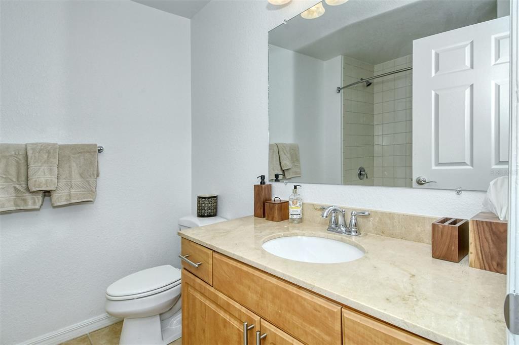 1064 North Tamiami Trail, Unit 1627 Sarasota, FL 34236 - Photo 27 of 97 a bathroom with a granite countertop sink a toilet and a mirror