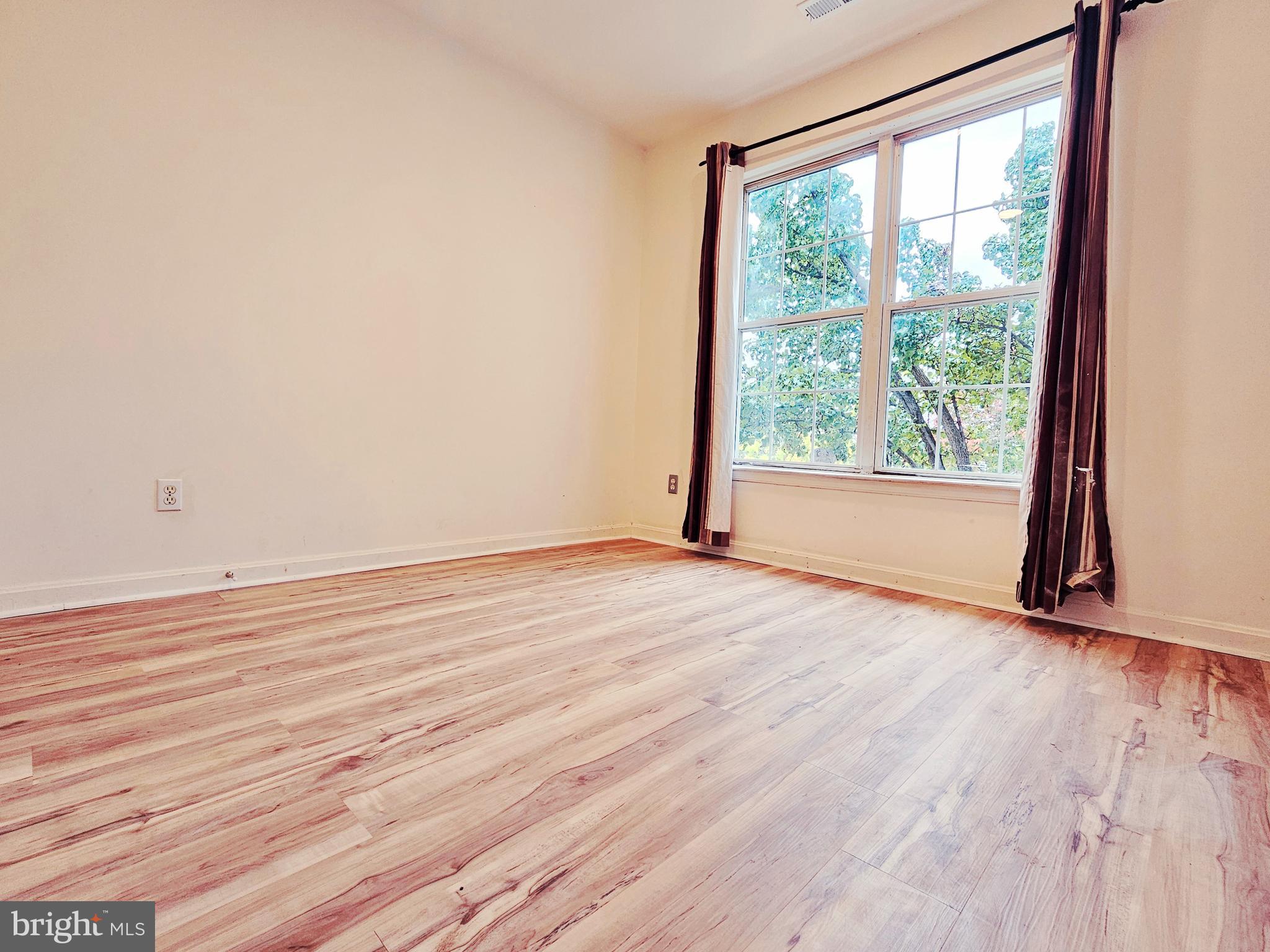 605 Villager Circle Baltimore, MD 21222 - Photo 16 of 41 a view of an empty room with wooden floor and a window