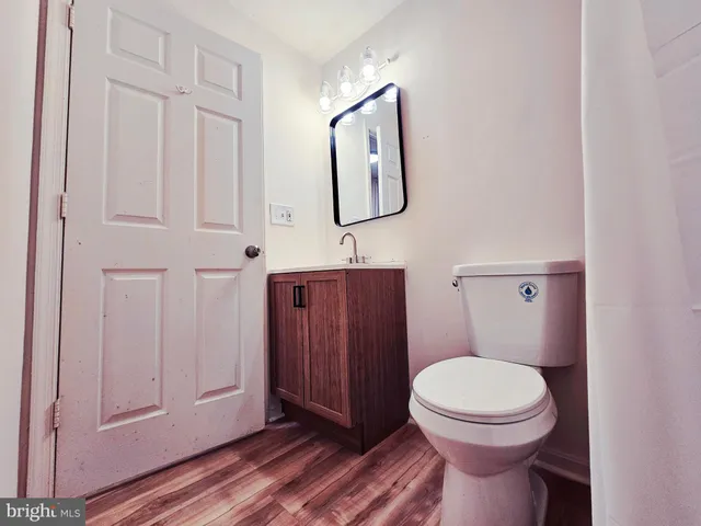 a bathroom with a toilet a sink a vanity and mirror
