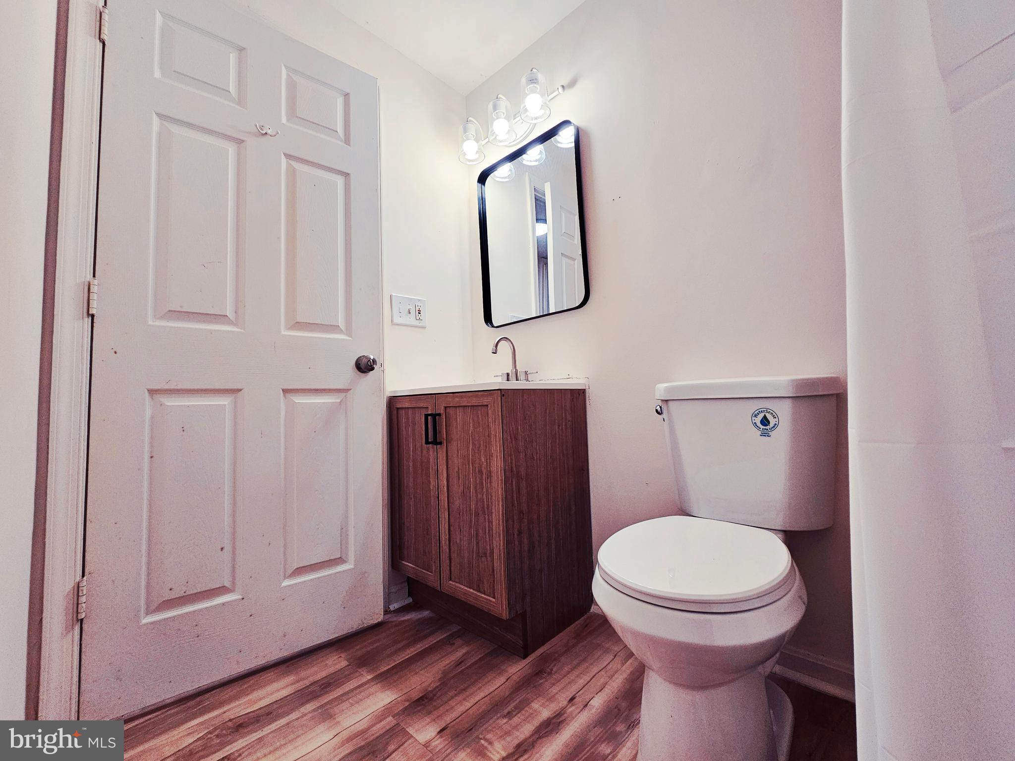 605 Villager Circle Baltimore, MD 21222 - Photo 34 of 41 a bathroom with a toilet a sink a vanity and mirror