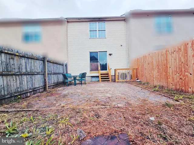 a view of a house with backyard and wooden fence