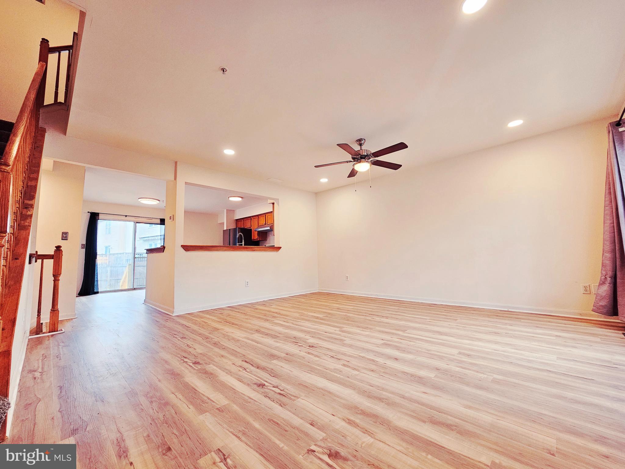 605 Villager Circle Baltimore, MD 21222 - Photo 5 of 41 a view of a big room with wooden floor and a ceiling fan