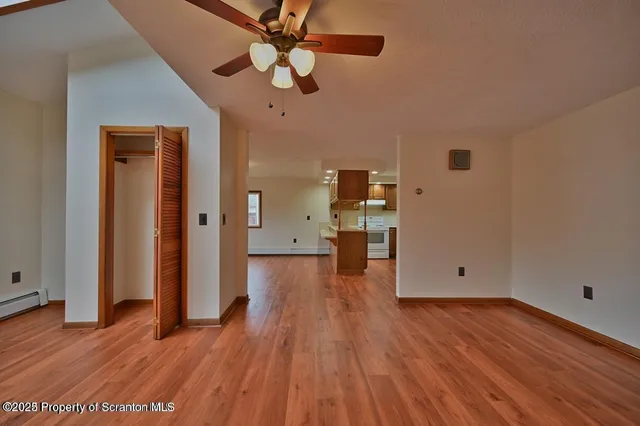 a view of empty room with wooden floor