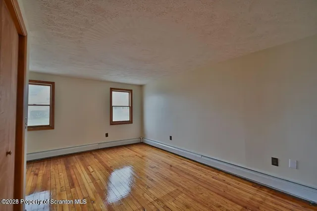 a view of room with window and wooden floor