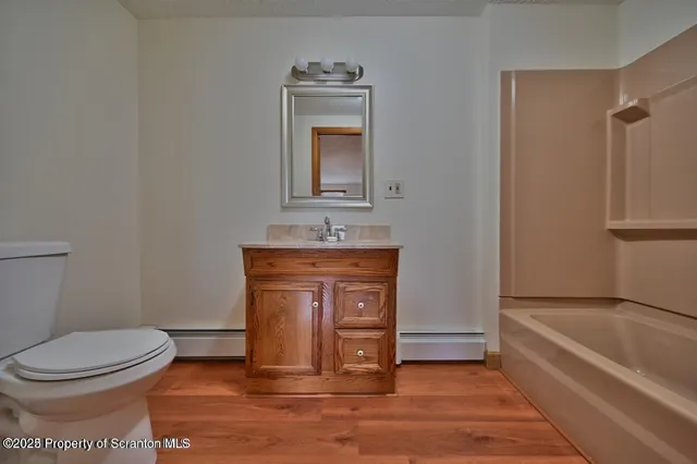 a bathroom with a toilet sink vanity and mirror