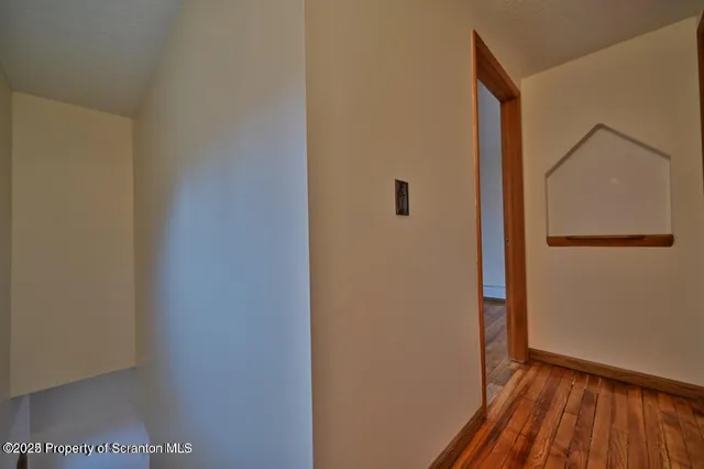 a view of a hallway with wooden floor and a hallway