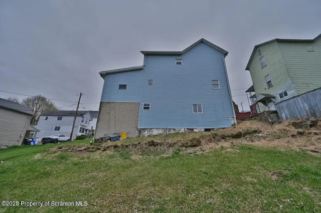 a view of an empty room with wooden floor and closet