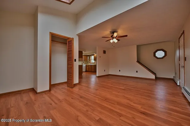 a view of a livingroom with a hardwood floor and a ceiling fan