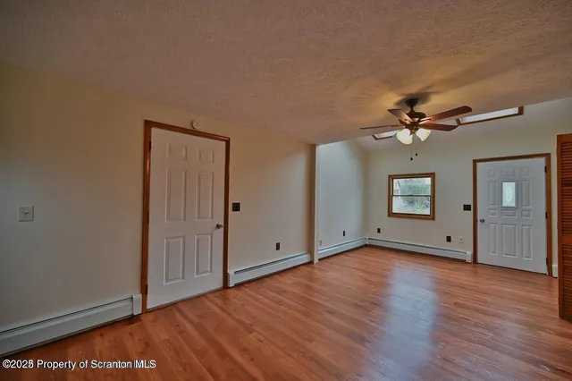 a view of empty room with wooden floor