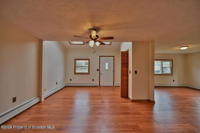 a view of a livingroom with wooden floor and a ceiling fan