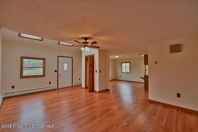 a view of a livingroom with wooden floor and a ceiling fan