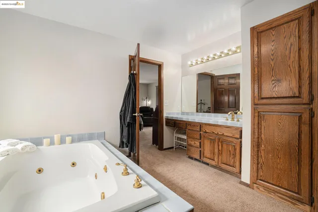 a bedroom with a bed and a lamp on dresser