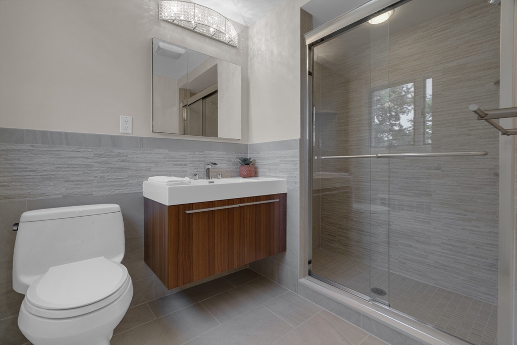 15 Marcellus Drive Newton, MA 02459 - Photo 11 of 27 a bathroom with a granite countertop toilet sink and mirror