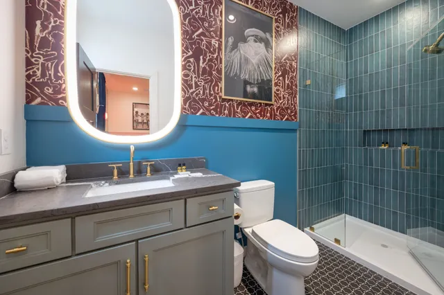 a kitchen with stainless steel appliances granite countertop a refrigerator a stove a sink a dining table and chairs with wooden floor