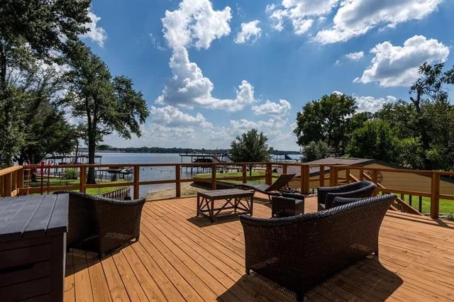 a view of a chairs on a deck with a barbeque grill