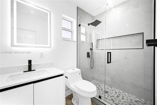 a bathroom with a sink toilet and shower