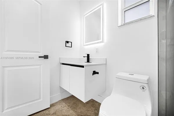 a white toilet sitting next to a bathroom sink
