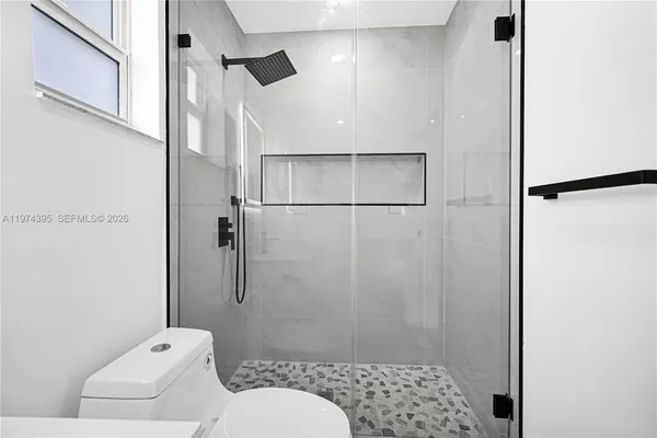 a bathroom with a toilet and a shower