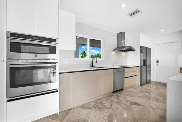 a kitchen with stainless steel appliances a stove microwave and a refrigerator